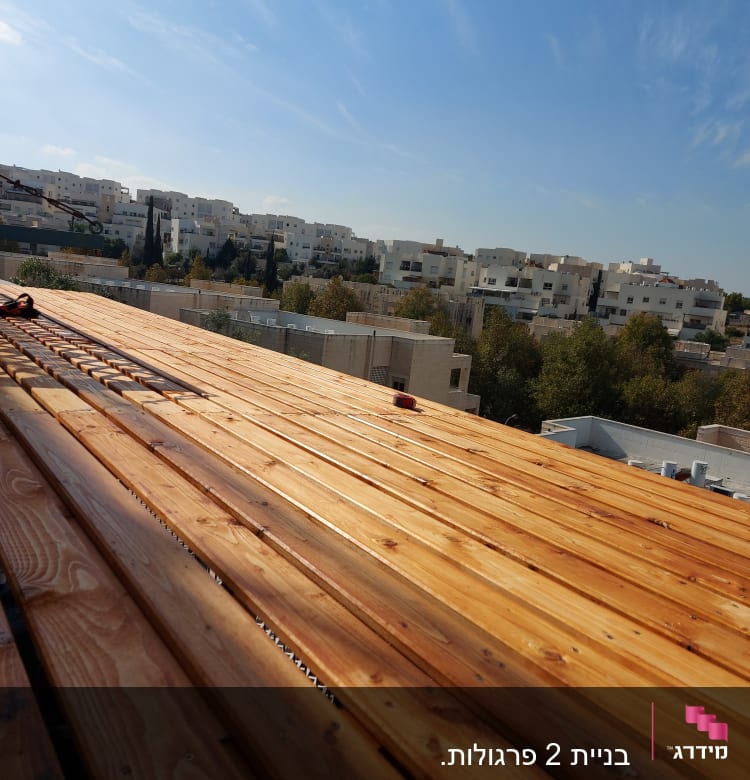 משטח עץ בנוי על גג עם שמיים כחולים